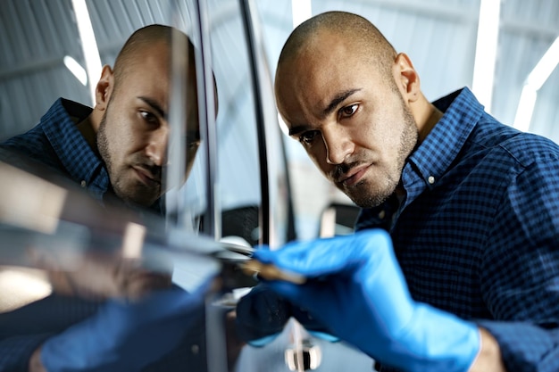 African american man car service worker applying nano coating on a car