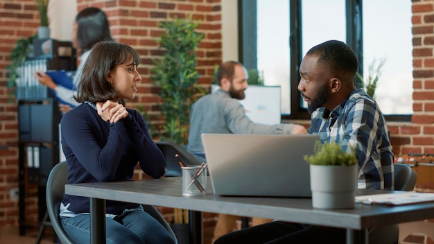 African american man greeting female applicant at hiring meeting, talking about corporate career opportunity. Confident woman attending employment job interview with male recruiter.