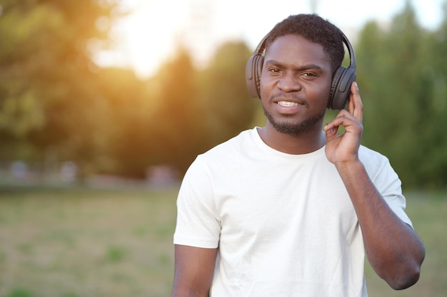 African american man in headphones listens to music in park