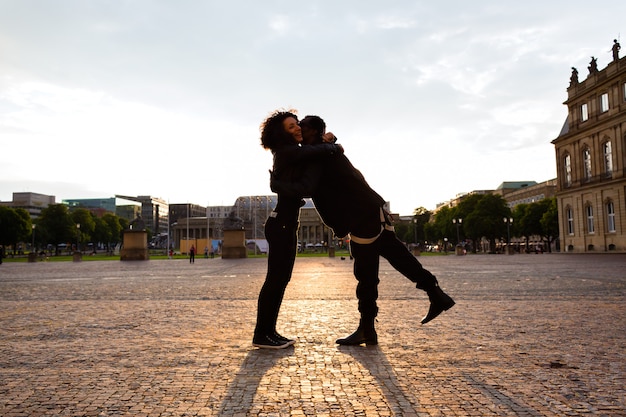 African American man hugging girlfriend in the city 