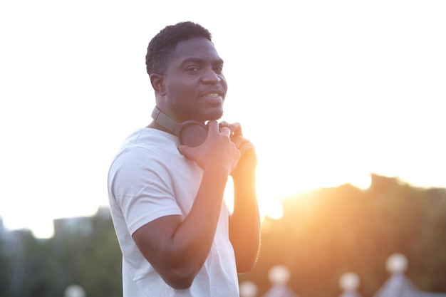 African american man putting on headphones looks with smile