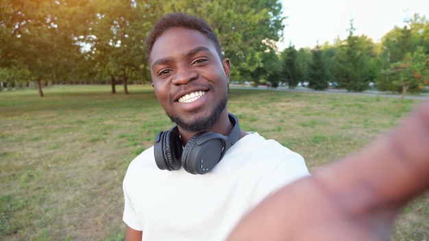 African american man records video on smartphone smiling