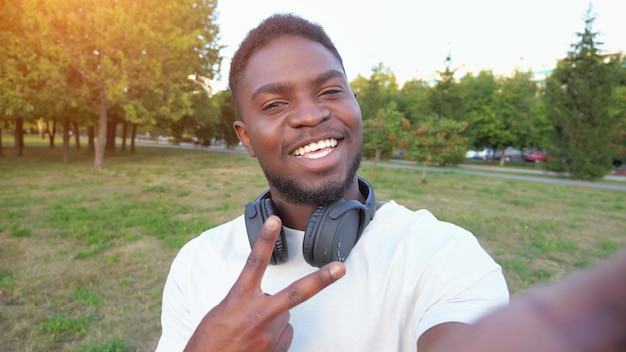 African american man records video on smartphone smiling