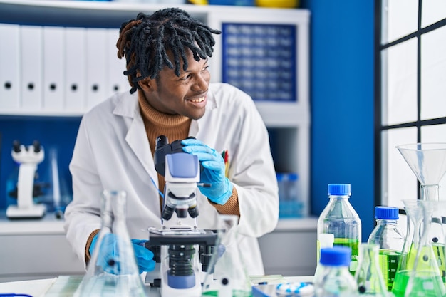 African american man scientist using microscope at laboratory