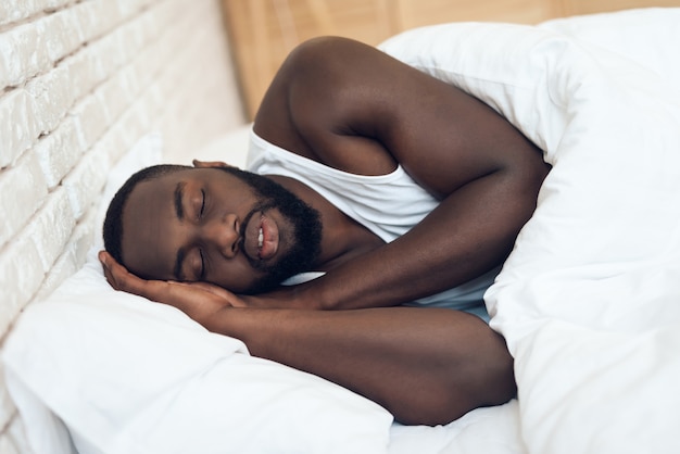 African American man sleeping in bed.