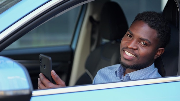 African american man talks with friend via videocall in car