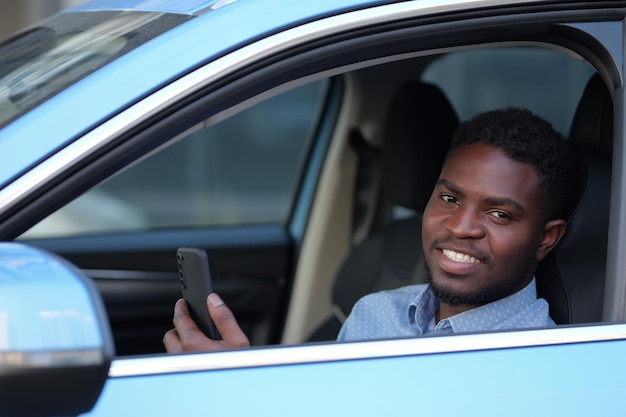 African american man talks with friend via videocall in car