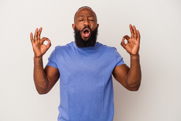 African american man with beard isolated on pink background relaxes after hard working day, she is performing yoga.