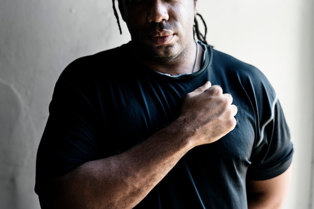 African American man with a fist over his chest