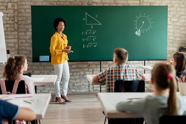 African American math teacher holding a class to her students in the classroom