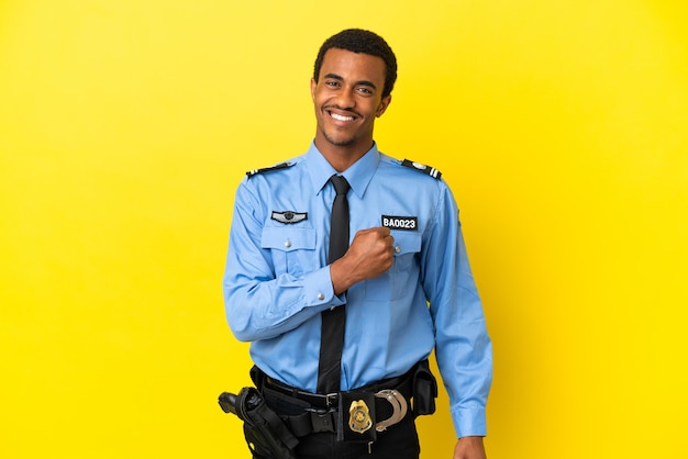 African American police man over isolated yellow background celebrating a victory