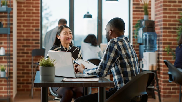 African american recruiter greeting asian woman at job interview, meeting to discuss about employment and career opportunity. Man talking to candidate with cv files about hiring concept.