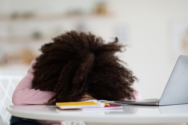 African american schooler lying on table sleeping