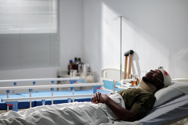 African american soldier lying on bed in military hospital after wound