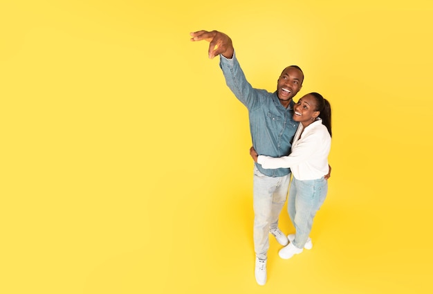 African American Spouses Advertising Something Holding Invisible Object Yellow Background