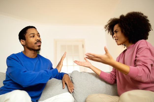 African american spouses quarreling sitting on sofa at home