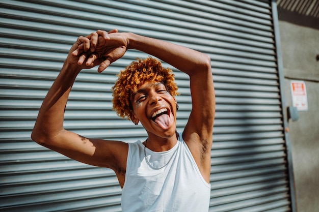 African american teenager with glitter on his face dancing at the street