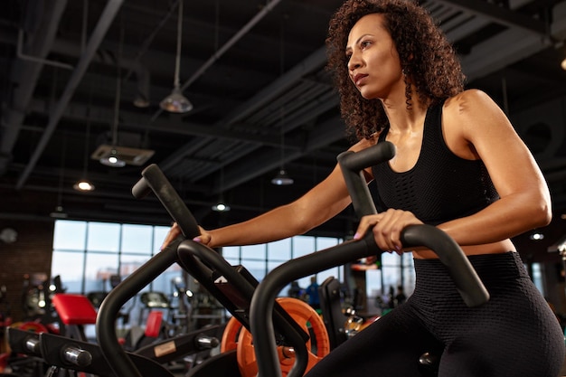 African American woman cardio for weight loss aerobics workout on bike active lifestyle share health regular workout