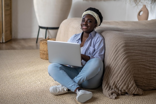 African american woman chatting on internet and looking interested