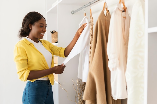 African american woman choosing clothes in wardrobe at home