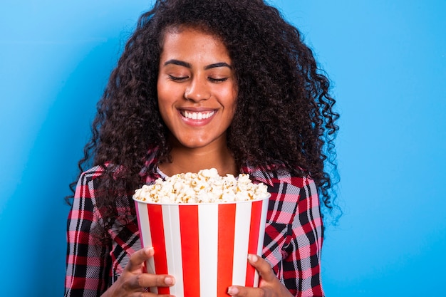 African american woman eating popcorn happy with big smile  