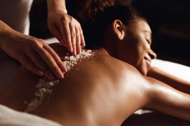 African-american woman having exfoliation treatment in spa salon