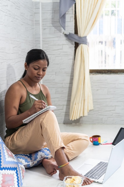 African American woman sitting on the floor working from home