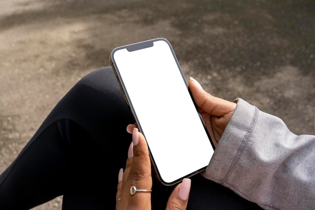 African American woman sitting in park with a mobile phone