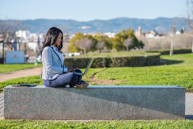 African-American woman using a laptop in an outdoor park