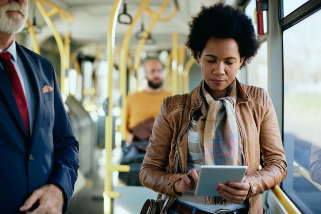 African American woman using touchpad while commuting by public transport