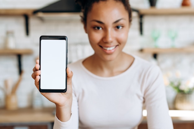 African American woman with a phone in the kitchen