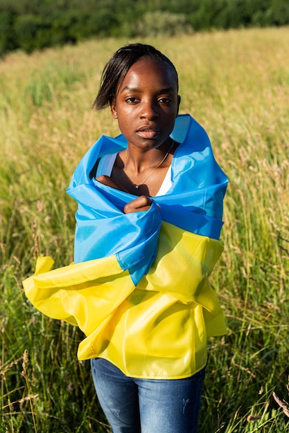 African american woman wrapped in ukrainian yellow blue flag national symbol of Ukraine