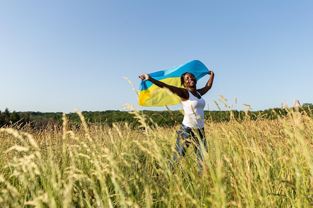 African american woman wrapped in ukrainian yellow blue flag national symbol of Ukraine