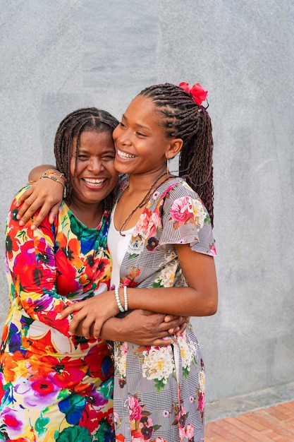 African American women mother and daughter hugging in the street