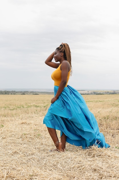 African american young woman having fun outdoors at sunset laughing girl on field beautiful young african american woman with pigtails