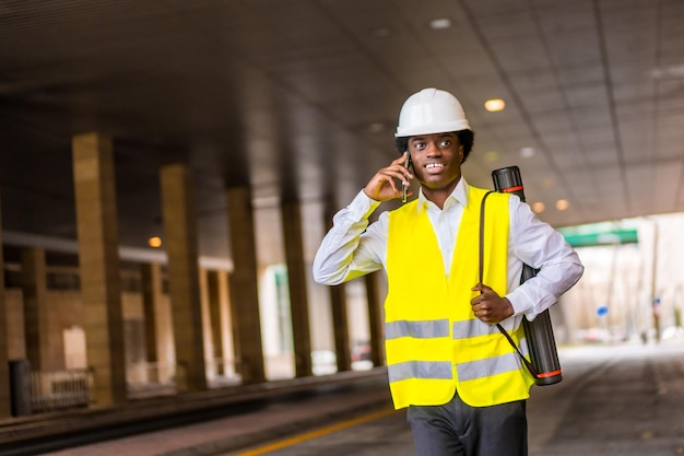 African architect talking to the mobile while walking outdoors