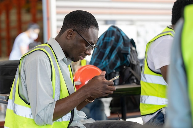 African Black worker relax playing mobile smart phone at lunch brake time rest happy smile