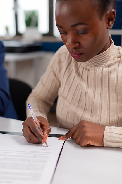 African businesswoman reading signing documents its while business partners sharing paperwork