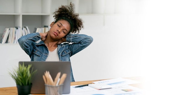 African Businesswoman with Neck Pain Using Laptop working at office