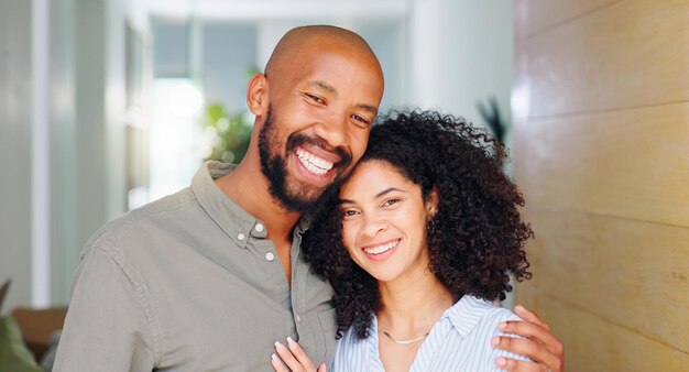 African couple smile and hug at front door in portrait with pride care and bonding at new home Man woman and happy together with embrace love and investment with property real estate or house