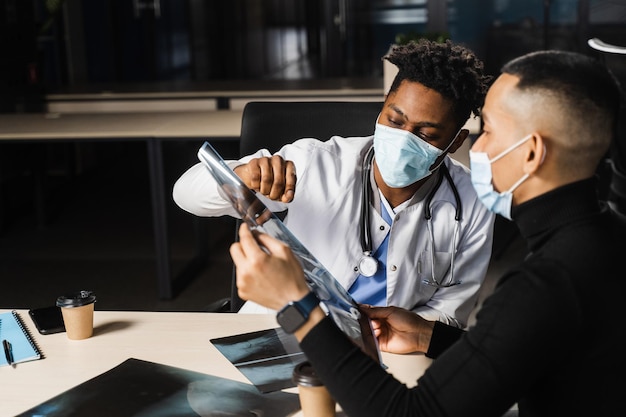 African doctor show xray asian patient Pneumonia and pleurisy Black surgeon analyzing x ray and diagnosis patient in medical clinic