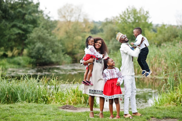 African family in traditional clothes at park.