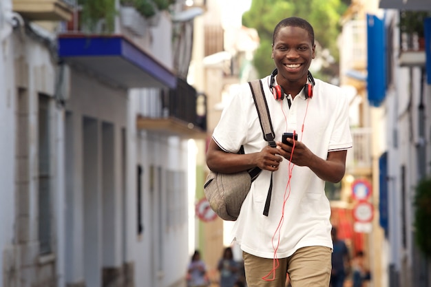 African guy walking on street with a phone