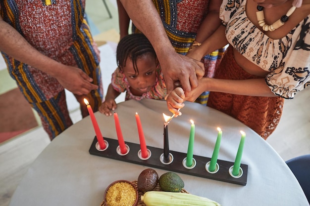 African little girl burning candles with family