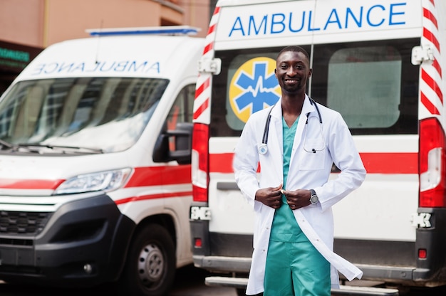 African male paramedic standing in front of ambulance car 