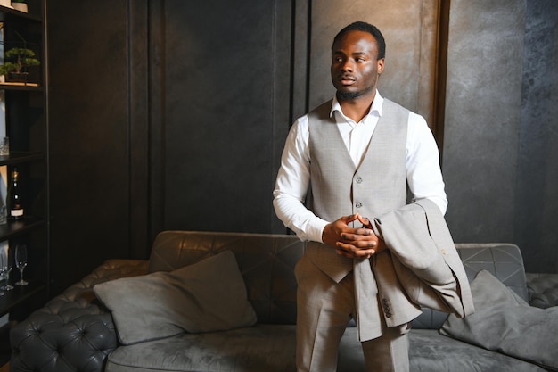 Photo african man in a classic suit on a dark gray background the concept of classic clothing