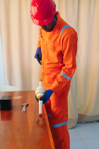 African Man is repairing a pipe at home