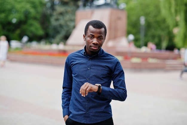 African man posed at street of city wear on blue shirt and black pants