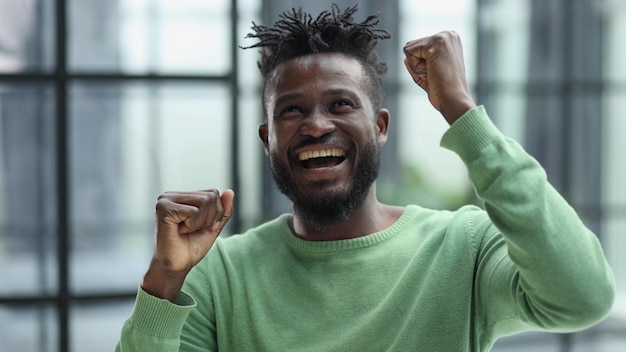 African man rejoices at the victory with his hands up