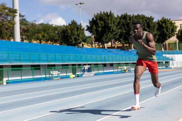 African man running on athletics track